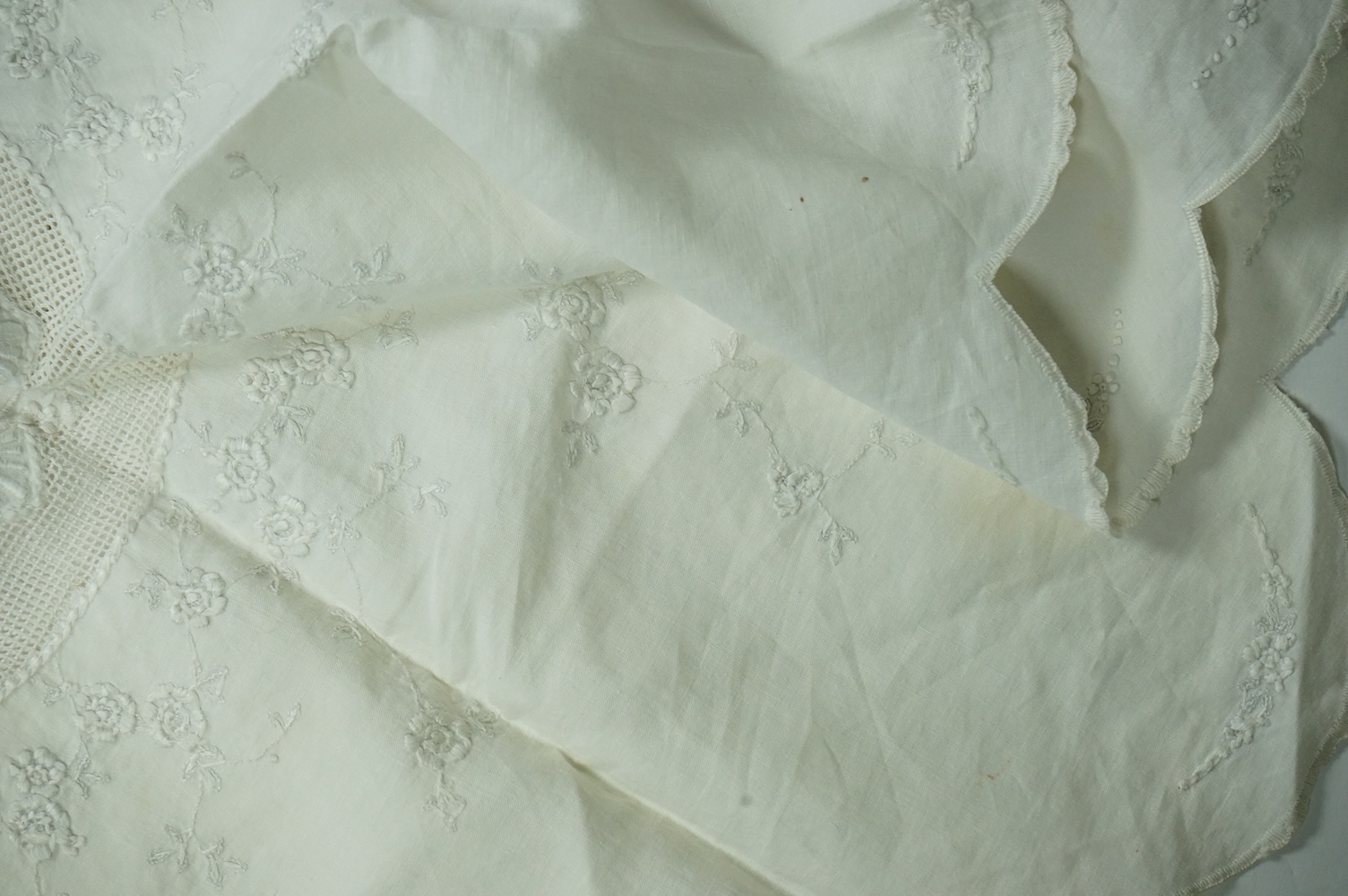 An unusual Victorian white linen hand worked table cloth. Embroidered along one edge, Wrought by L. Grover for her daughter Ethel Frances Burbury 1895. Together with three crochet edged cloths and a circular embroidered